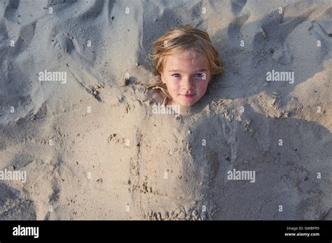 Girl Buried In The Sand At The Beach Stock Photo Alamy