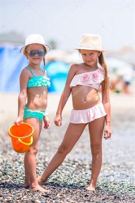 Adorables niñas divirtiéndose durante las vacaciones en la playa fotografía de stock d