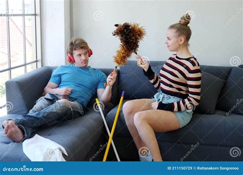 Lazy Caucasian Husband Listen To Music With Red Headphone And Wife Relaxing With Spray Together