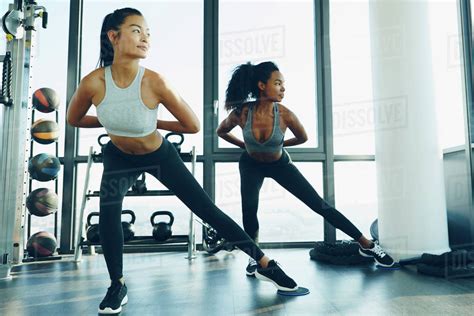 Two Young Women Exercising In Gym Doing Aerobic Workout Stock Photo