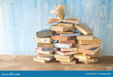 Opened Book On A Large Pile Of Books Reading Educationliterature