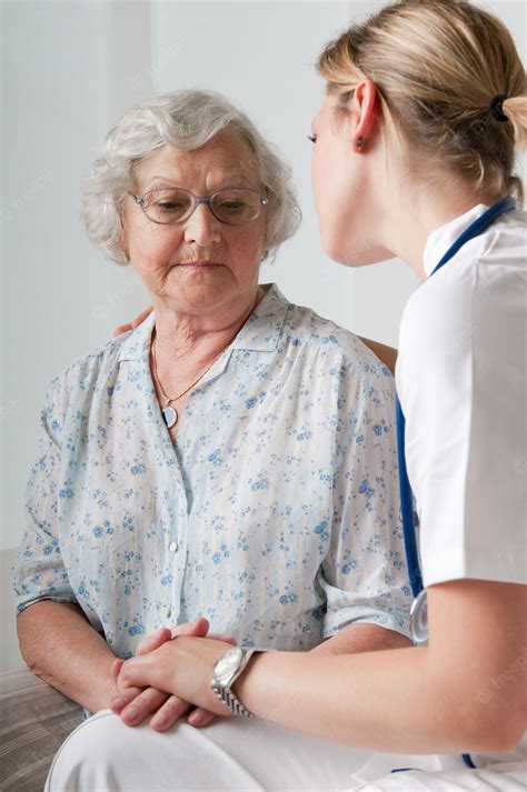 Premium Photo Young Nurse Consoling And Taking Care Of Senior Patient