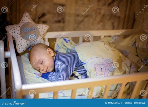 Adorable Newborn Baby Boy Sleeping In Crib At Night Stock Image