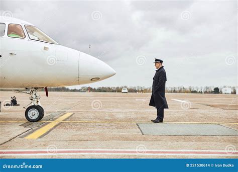 Pilot Standing On Runway And Looking On Airplane Stock Photo Image Of