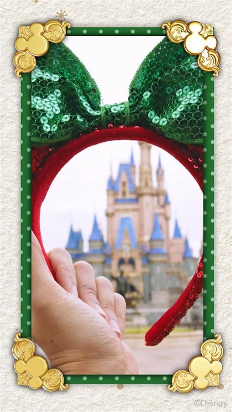 A Hand Holding A Red Minnie Mouse Ears Headband In Front Of A Castle