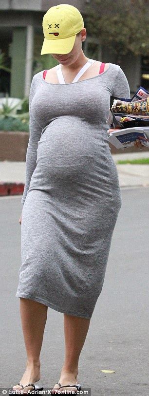 Amber Rose Displays Her Huge Belly In A Tight Lycra Dress As She