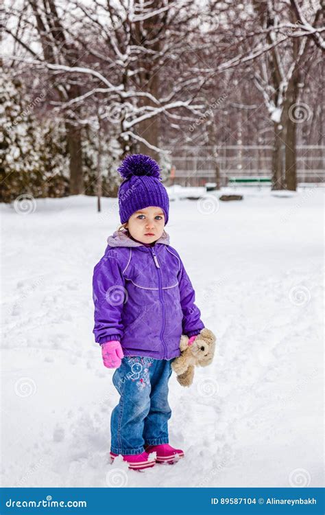 Cute Little Girl Is Standing In Snow Falling Background