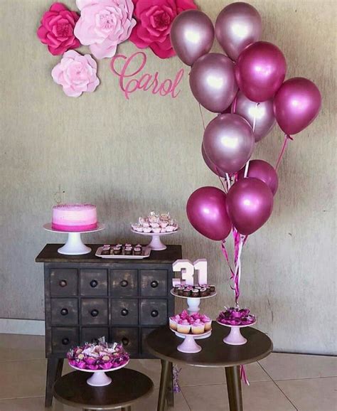 A Table Topped With Lots Of Pink And Purple Balloons