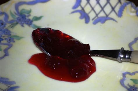 A Spoon With Some Jelly On It Sitting On A Plate Next To A Flowered Design