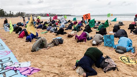 Climate Activists Bury Their Heads In The Sand On Manly Beach