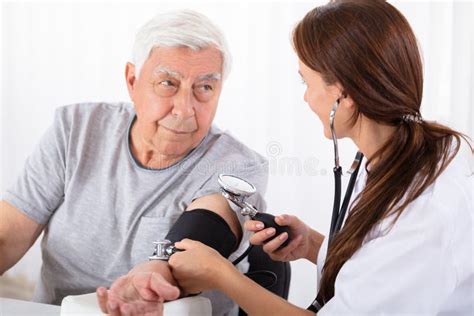 Doctor Checking Blood Pressure Of Male Patient Stock Photo Image Of