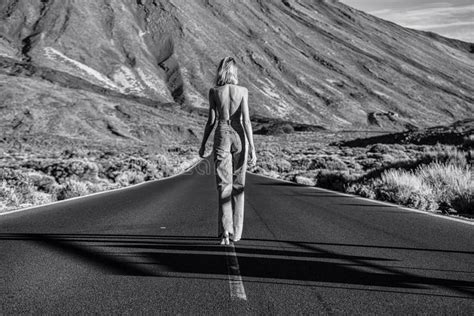 Woman Topless Traveler In Jeans Walking Away On The Street Over The Wild Mountains Landscape