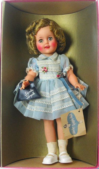 The Doll Is Wearing A Blue Dress And White Shoes With Her Name On Its