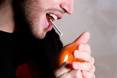 Man Lights A Stick Of Sucking Candy That He Holds In His Mouth Stock