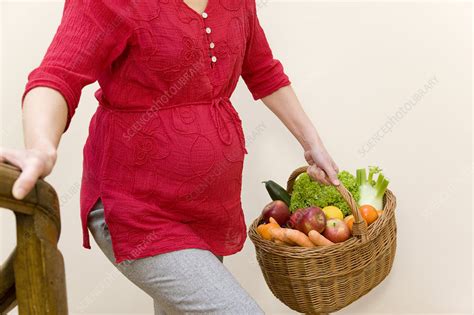Pregnant Woman Carrying Fruit Basket Stock Image F003 7188 Science Photo Library