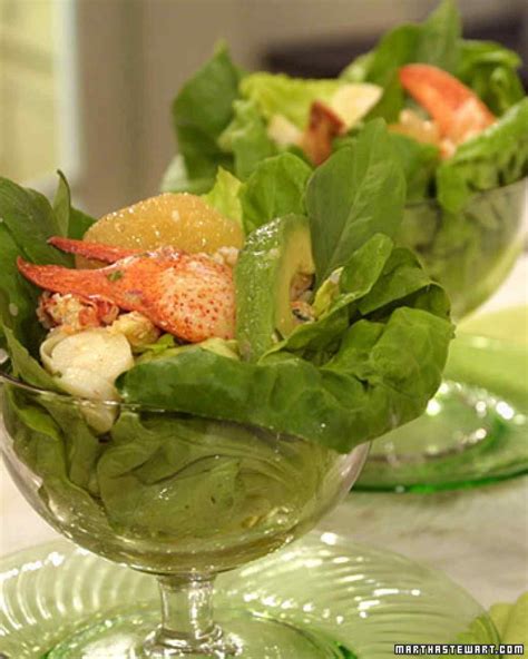 Two Glass Bowls Filled With Lettuce And Crab Salad On Top Of A Table