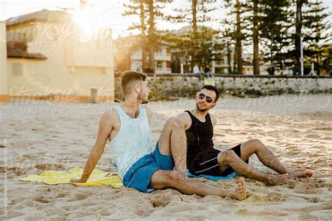Male Friends Listening To Music On The Beach By Jayme Burrows