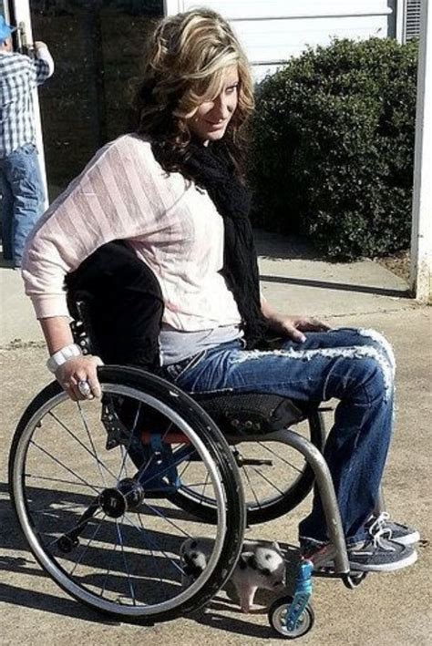A Woman Sitting In A Wheel Chair On The Sidewalk