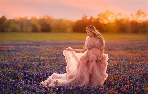 Обои поле небо свет закат цветы поза настроение женщина платье живот розовое