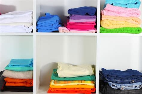 Premium Photo Clothes Neatly Folded On Shelves