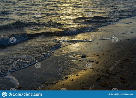 Scenic View Of Ocean Waves Washing The Sandy Beach On A Sunny Day Stock