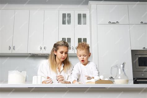 Maman Et Enfant Cuisinent Dans Une Cuisine Blanche En Pâte Photo Premium