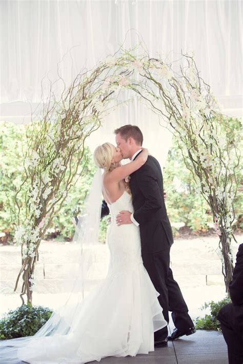 First Kiss Under White Branch Wedding Arch