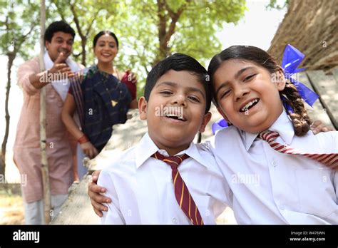 Portrait Of School Children Smiling With Their Parents Standing In The