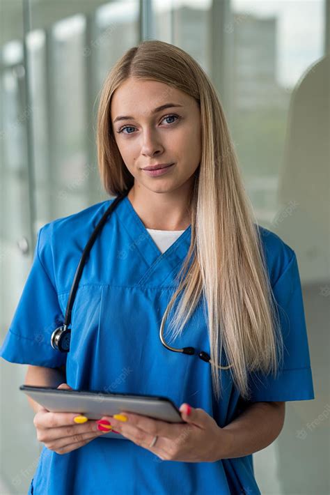 Hermosa Joven Enfermera Con Un Estetoscopio Y Una Tableta En El Pasillo