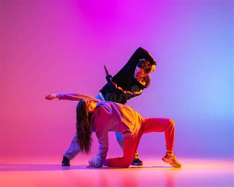 Two Young People Guy And Girl In Casual Clothes Dancing Contemporary Dance Hip Hop Over Pink