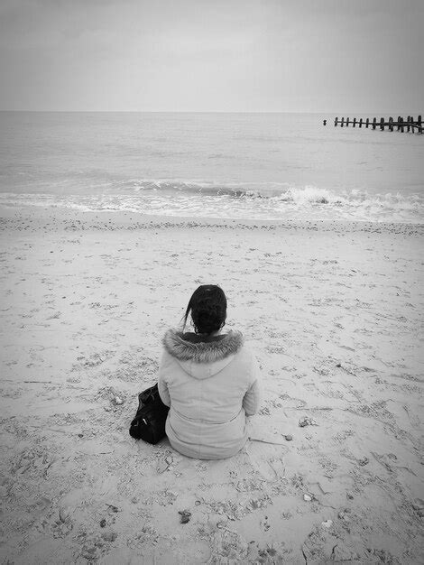 Premium Photo Rear View Of Woman Sitting On Beach
