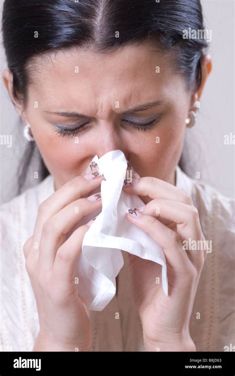 Sick Woman Blowing Nose With A Tissue Stock Photo Alamy