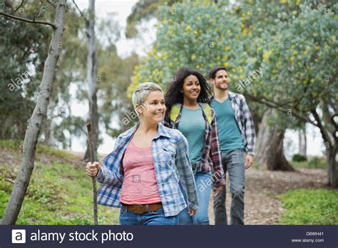 Happy Friends Hiking Together In Forest Stock Photo Alamy