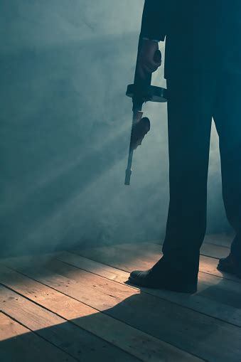 Retro Gangster Stands With Machine Gun In Smoky Room Rear View Stock