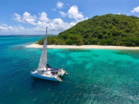 a boat sails through dominica as one of the adventures you can do with select yachts
