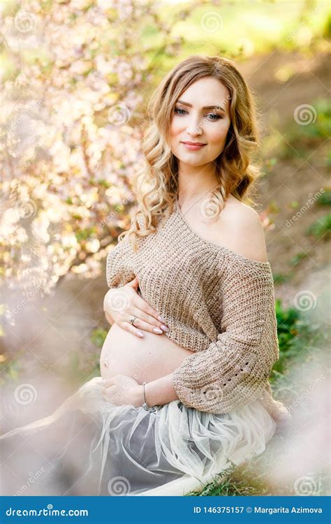 Beautiful Pregnant Woman Sitting Near The Cherry Blossom Pregnant