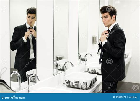 Man Getting Dressed In A Public Restroom With Mirror Stock Image