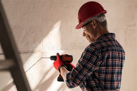 A Man Drilling A Hole In The Wall Stock Photo Image Of Handyman