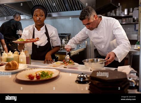 Chefs Working In Busy Restaurant Kitchen Stock Photo Alamy