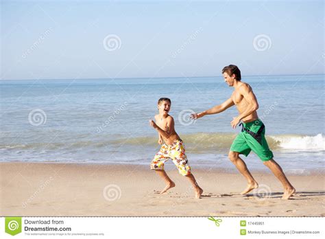 Father Chasing Young Boy On Beach Stock Image Image Of Together