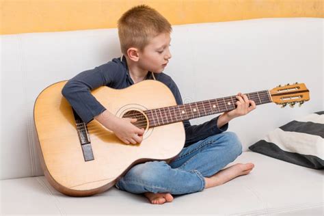 A Young Boy Is Playing Guitar Stock Photo Image Of Guitar Indoor