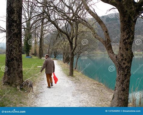 Man With The Dog Near The Mountain Lake With Turquoise Blue Water And