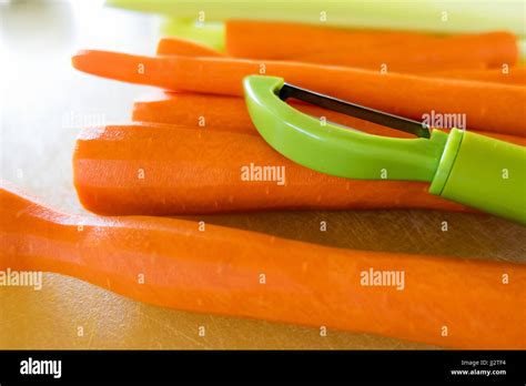 Un éplucheur à Carottes Vert Assis Sur Pile De Carottes Sur Une Planche