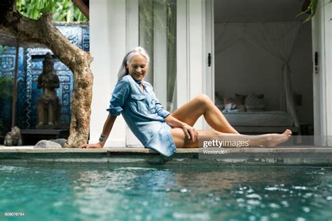 Beautiful Senior Woman Relaxing At Pool In Front Of Her House Photo