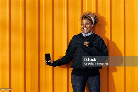 Photo Libre De Droit De Femme Afroaméricaine Heureuse Debout Devant Un Conteneur Orange