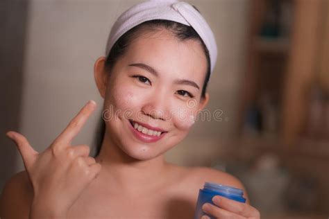 Domestic Lifestyle Portrait Of Young Beautiful And Happy Asian Korean Woman Applying Facial