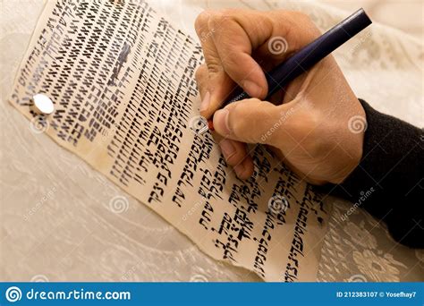 A Writer`s Hand Practices Decorating Letters From A Torah Scroll