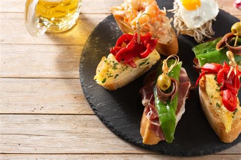 Premium Photo Assortment Of Spanish Pintxos On Wooden Table Typical Spanish Food