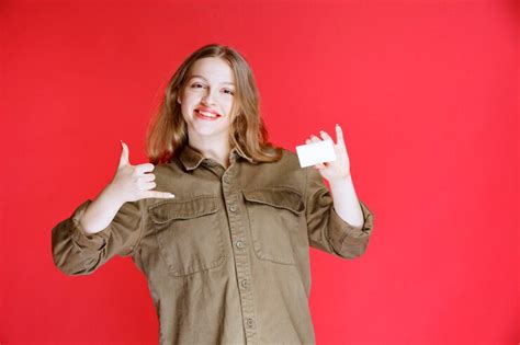 free photo blonde girl showing her business card and positive hand sign