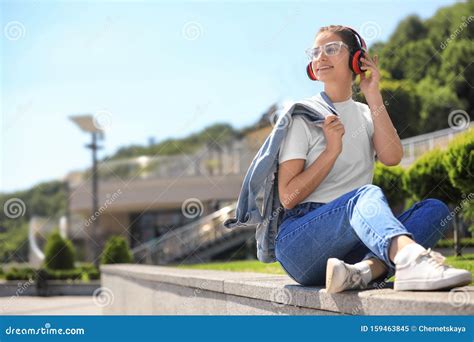 Young Woman With Headphones Listening To Music On City Street Stock